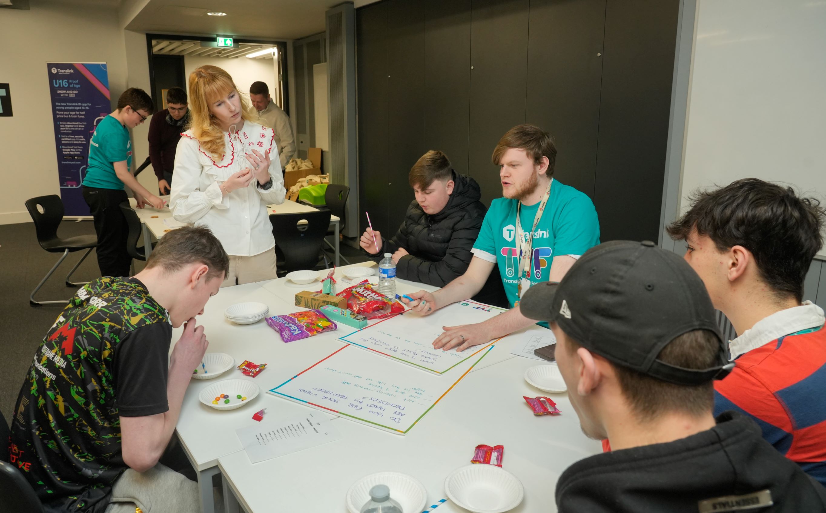 A photo showing young people taking part in the 2025 Translink Youth Forum conference sitting around a table talking