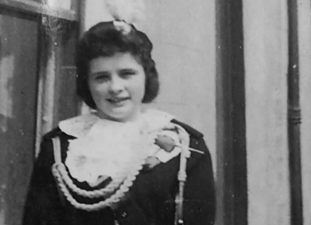 An old black and white photo of a young girl in traditional Ulster Scots costume