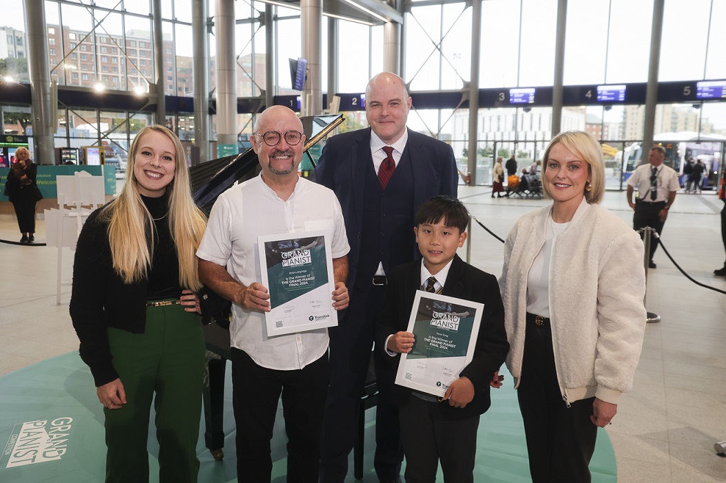 Winners of the Grand Pianist competition standing in Belfast Grand Central Station holding certificates