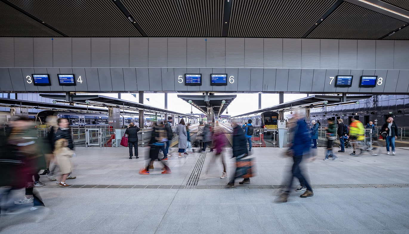A photo showing passengers walking in front of the platforms at Belfast Grand Central Station